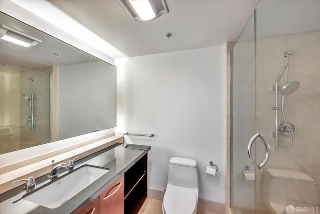 bathroom featuring toilet, visible vents, a shower stall, and vanity