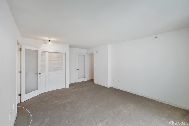 unfurnished bedroom with carpet floors, a closet, and baseboards