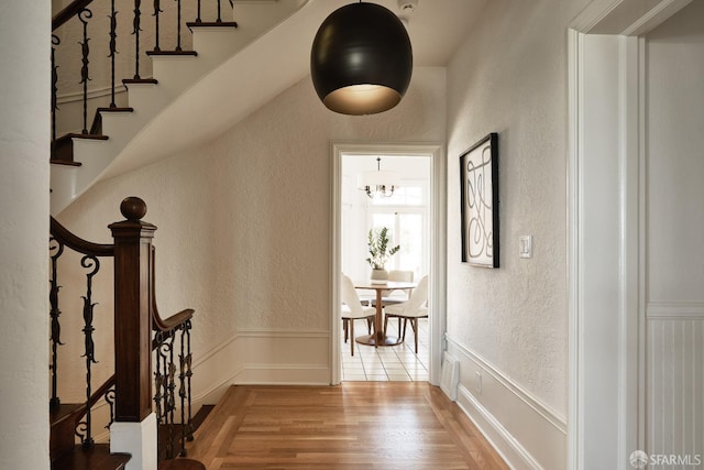 hallway with a chandelier and hardwood / wood-style floors