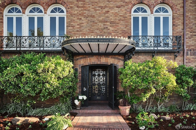 view of exterior entry with a balcony