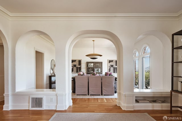 hall with wood-type flooring and ornamental molding