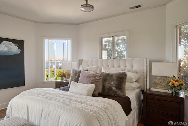 bedroom featuring multiple windows, ornamental molding, and hardwood / wood-style flooring