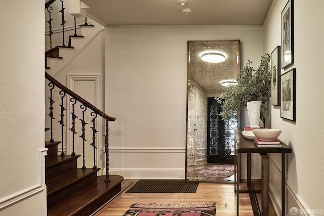 entrance foyer with hardwood / wood-style floors and crown molding