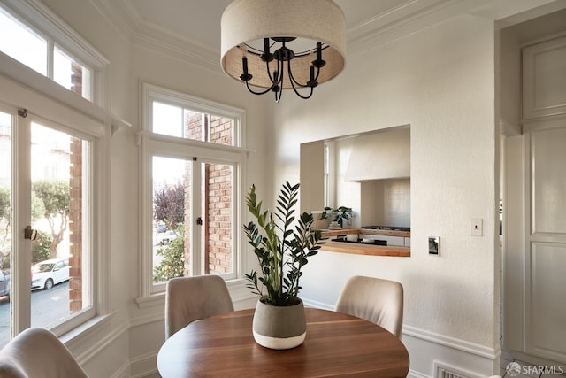 dining area with ornamental molding and a notable chandelier