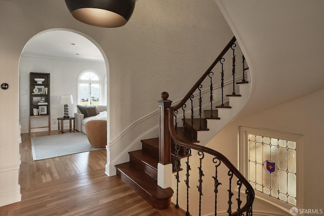 stairs featuring crown molding and hardwood / wood-style floors