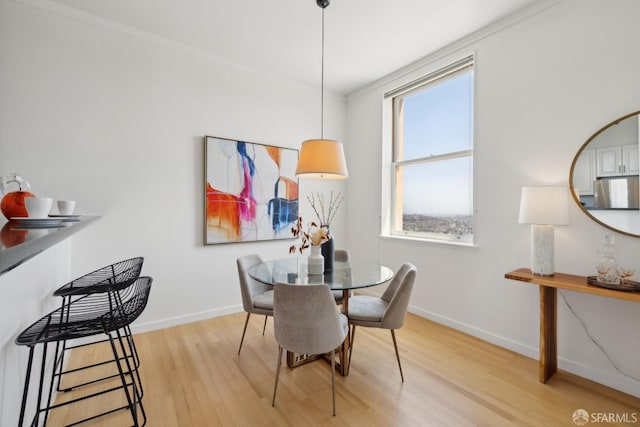 355 Buena Vista E Avenue 605W, San Francisco, CA 94117 - dining space featuring baseboards, light wood-style flooring, and crown molding