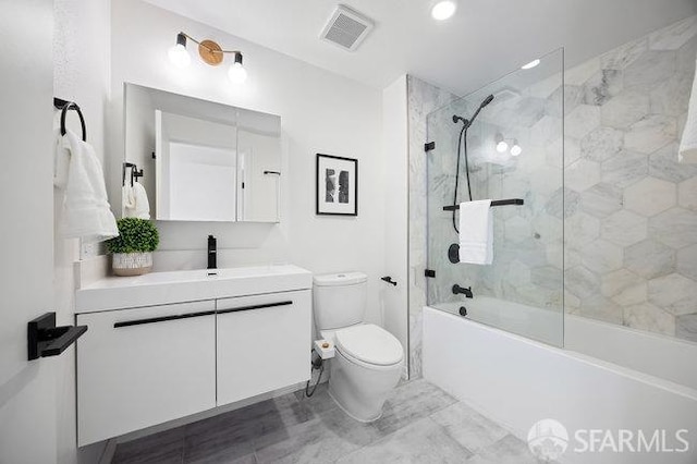 full bathroom featuring tiled shower / bath, vanity, and toilet