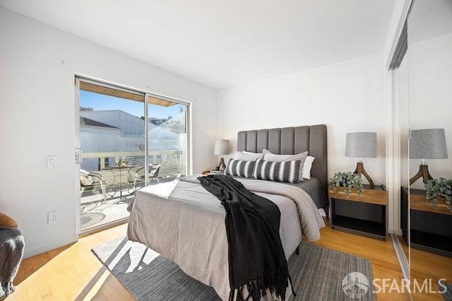 bedroom with access to outside and light wood-type flooring