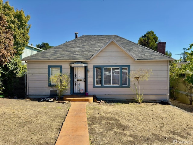 3838 Buell St, Oakland, CA 94619 - bungalow-style house with a shingled roof, fence, and a chimney