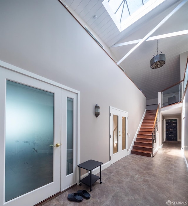 interior space featuring french doors, a skylight, and high vaulted ceiling