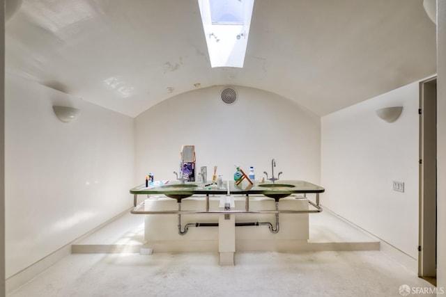 recreation room featuring vaulted ceiling with skylight