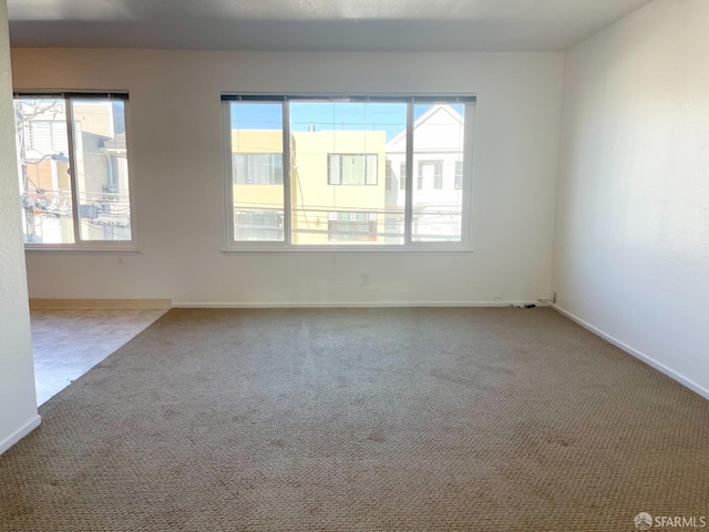 carpeted spare room featuring baseboards