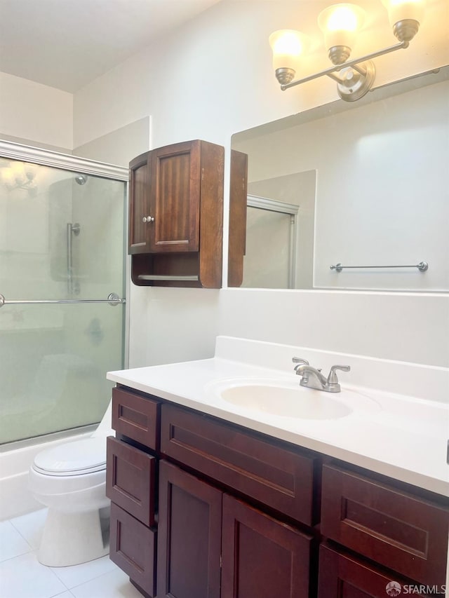 bathroom with toilet, shower / bath combination with glass door, vanity, and tile patterned floors