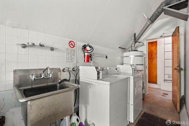 washroom with water heater, a sink, and separate washer and dryer