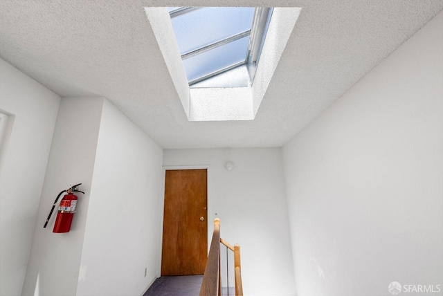 empty room with a skylight and a textured ceiling