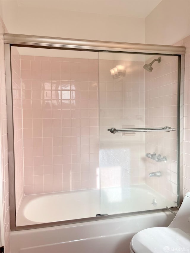 full bathroom featuring combined bath / shower with glass door and toilet