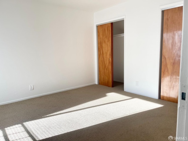 unfurnished bedroom featuring carpet floors and baseboards