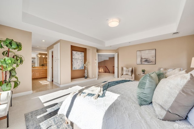 carpeted bedroom featuring visible vents, connected bathroom, baseboards, a tray ceiling, and recessed lighting