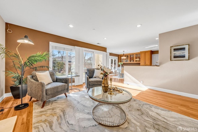 living area featuring light wood finished floors, recessed lighting, and baseboards