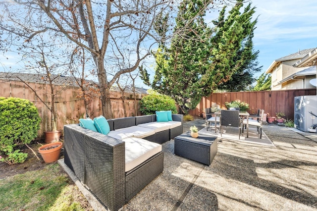 view of patio featuring an outdoor living space, a fenced backyard, and outdoor dining space