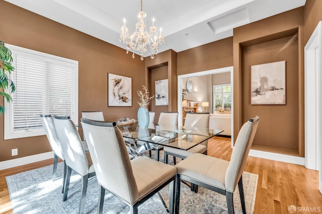 dining space with an inviting chandelier, light wood-type flooring, and baseboards