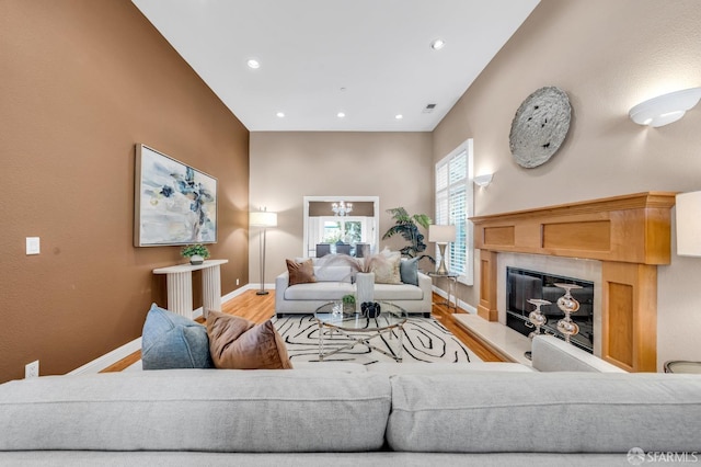 living room featuring visible vents, baseboards, recessed lighting, a fireplace, and wood finished floors