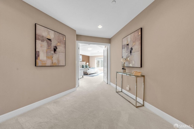 hallway featuring baseboards and carpet floors