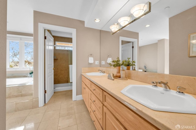 bathroom with a sink, a garden tub, double vanity, and tile patterned floors