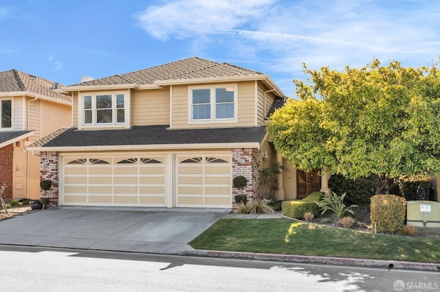 traditional-style home featuring a garage, brick siding, and driveway