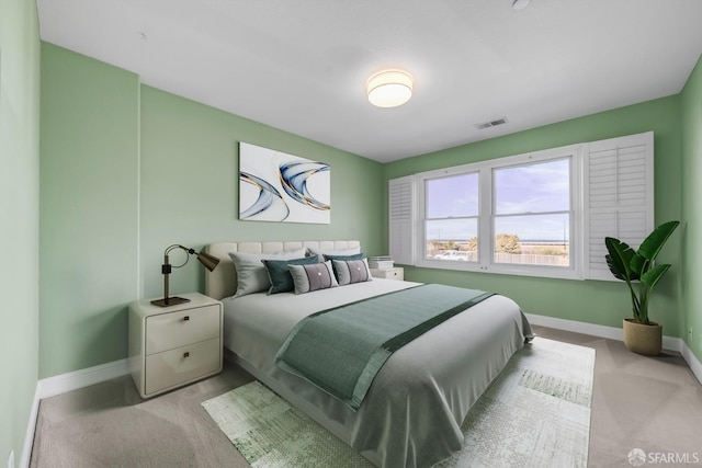 bedroom featuring visible vents, light colored carpet, and baseboards