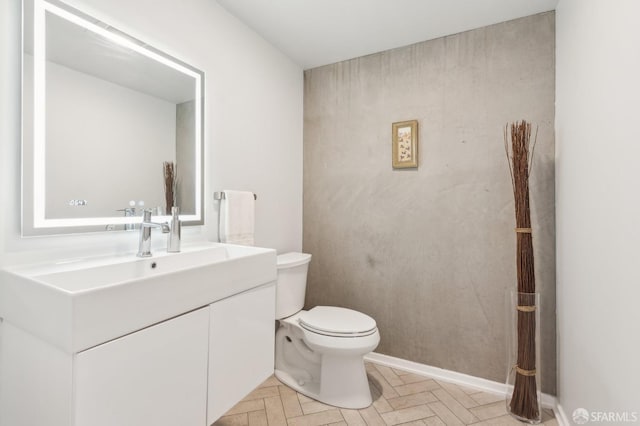 bathroom featuring vanity, parquet flooring, and toilet