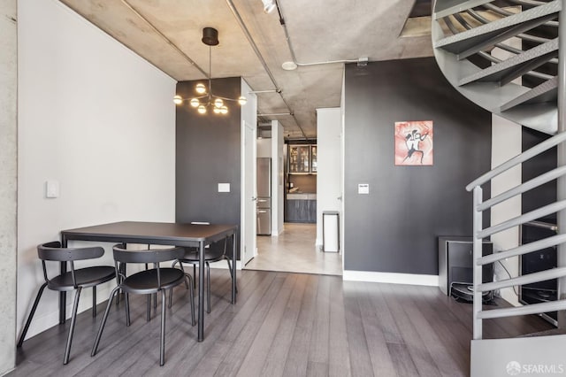 dining space with hardwood / wood-style flooring and a chandelier