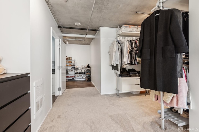 walk in closet featuring light carpet