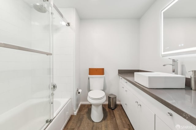 full bathroom with toilet, vanity, shower / bath combination with glass door, and wood-type flooring