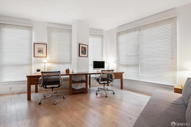 office space with a wealth of natural light and light hardwood / wood-style flooring