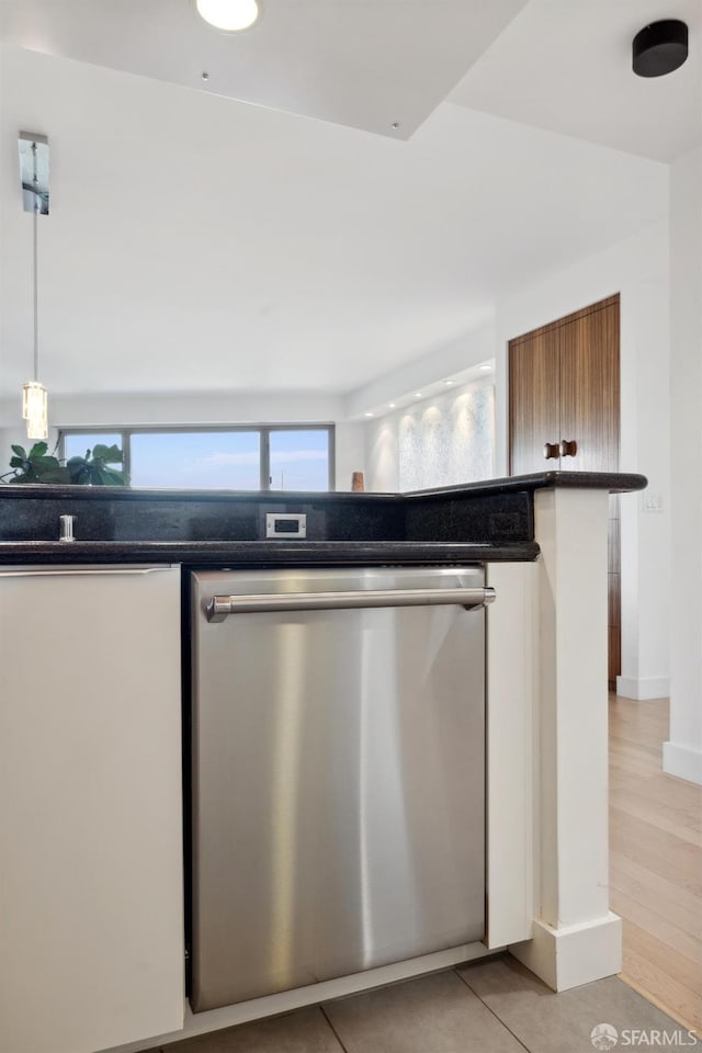 kitchen featuring pendant lighting, dishwasher, and light tile patterned flooring