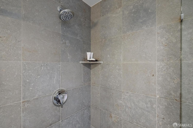 interior details with a tile shower