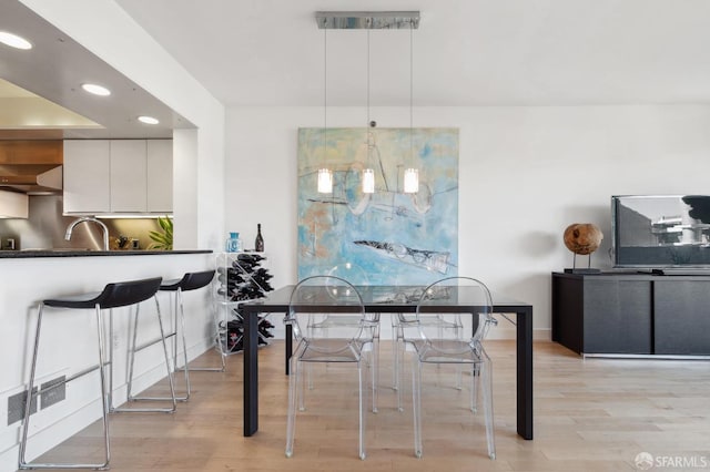 dining space featuring sink and light hardwood / wood-style floors