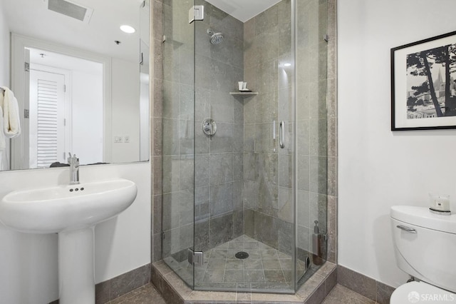 bathroom with an enclosed shower and toilet