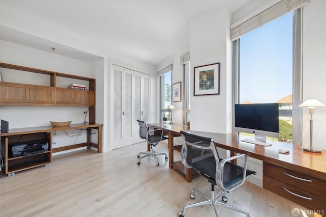 home office with light hardwood / wood-style flooring