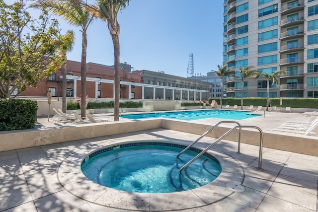 view of pool with a patio area and a hot tub