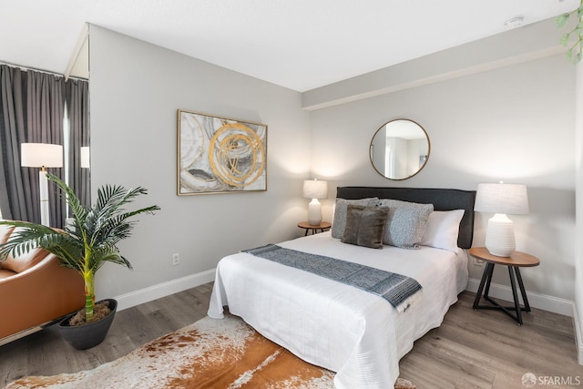 bedroom featuring light wood-style floors and baseboards