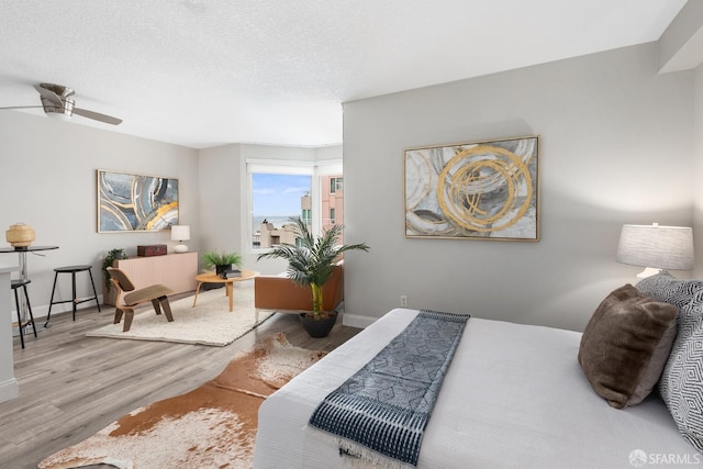 bedroom featuring ceiling fan, a textured ceiling, and hardwood / wood-style floors