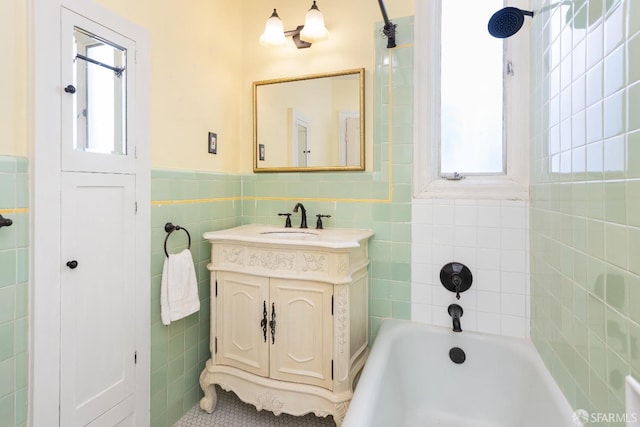 full bath with a wainscoted wall, a bathing tub, tile walls, and vanity