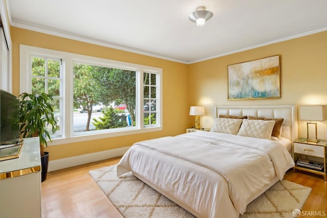 bedroom with baseboards, crown molding, and wood finished floors