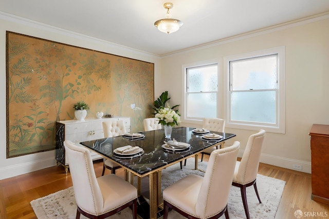 dining area featuring light wood-style floors, baseboards, and crown molding