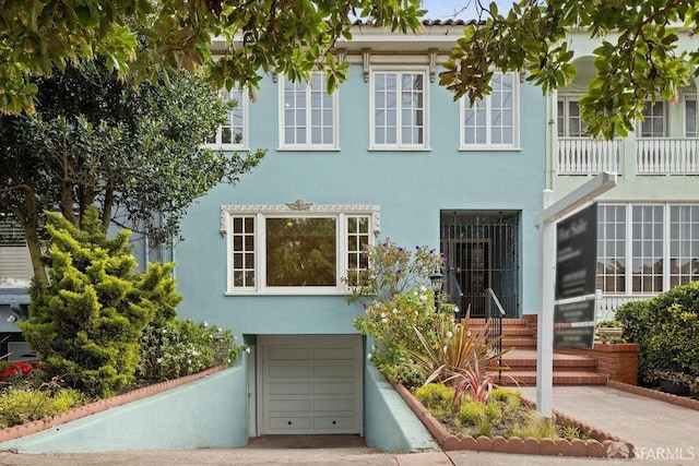 view of front of property featuring an attached garage and stucco siding