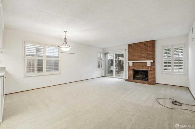 unfurnished living room featuring plenty of natural light, carpet, and a textured ceiling