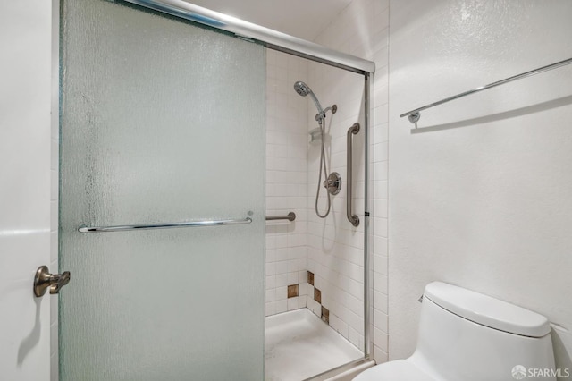 bathroom featuring a shower stall and toilet