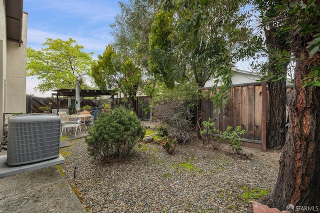 view of yard with a patio, central AC unit, a pergola, and a fenced backyard